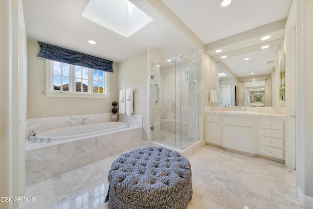 bathroom with vanity, a skylight, and shower with separate bathtub