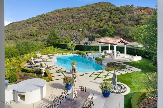 view of pool with a gazebo, a mountain view, a yard, and a patio area