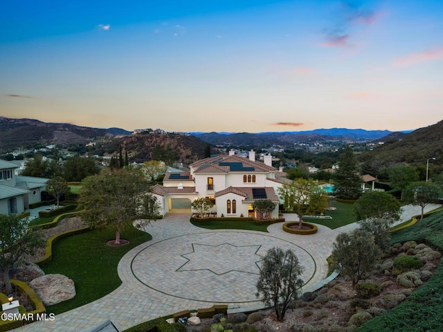 aerial view at dusk featuring a mountain view