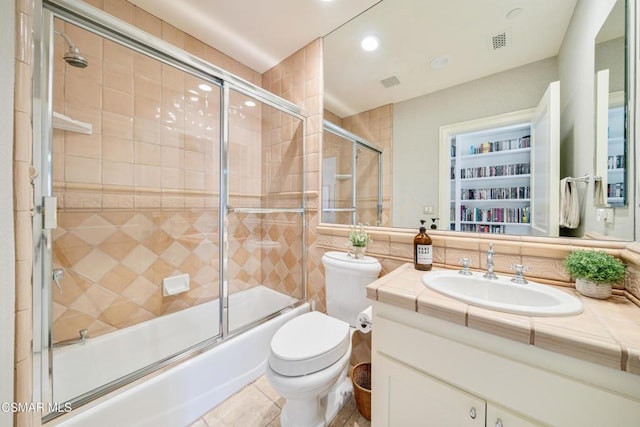 full bathroom featuring tile patterned flooring, vanity, shower / bath combination with glass door, and toilet