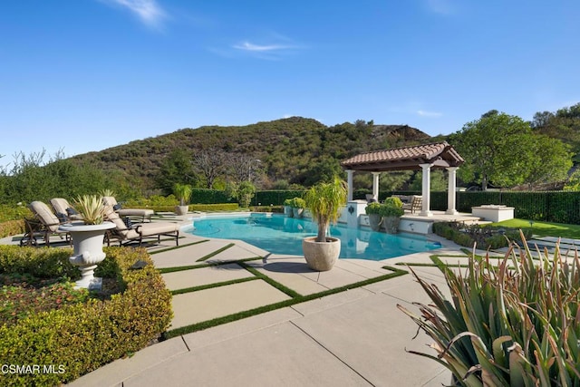 view of swimming pool with a gazebo, a mountain view, and a patio area