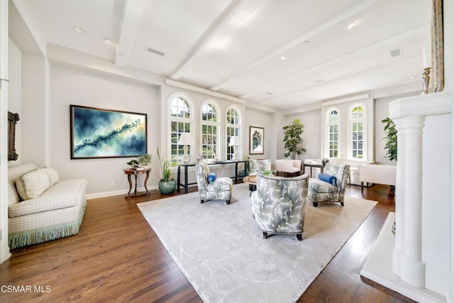 living room with beam ceiling, wood-type flooring, and ornate columns