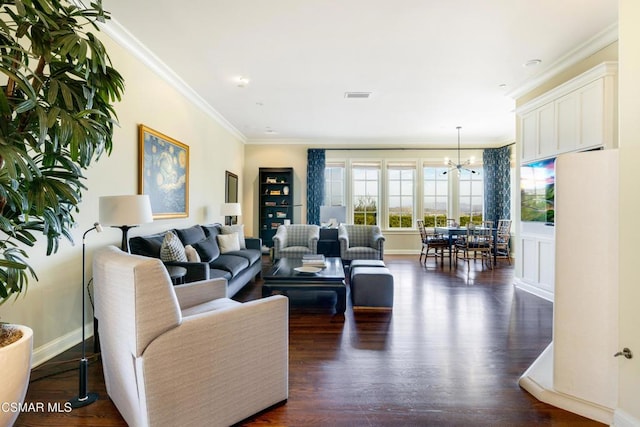 living room featuring crown molding, dark wood-type flooring, and an inviting chandelier