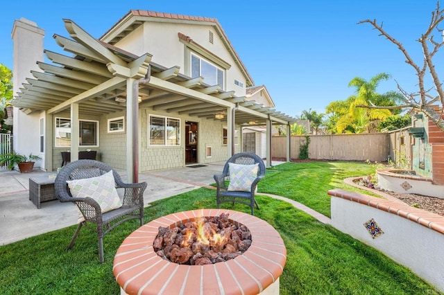 rear view of property featuring a pergola, a fire pit, a lawn, and a patio