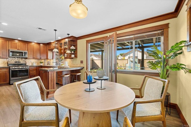 dining room featuring ornamental molding and light hardwood / wood-style floors