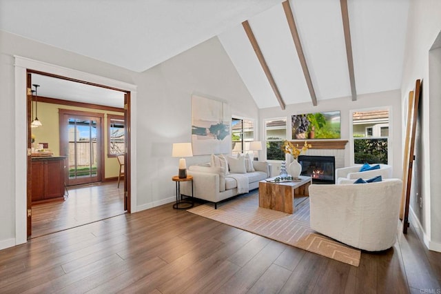 living room with beam ceiling, dark wood-type flooring, a wealth of natural light, and high vaulted ceiling