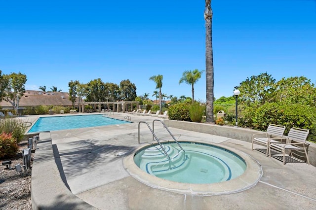 view of swimming pool featuring a hot tub and a patio area