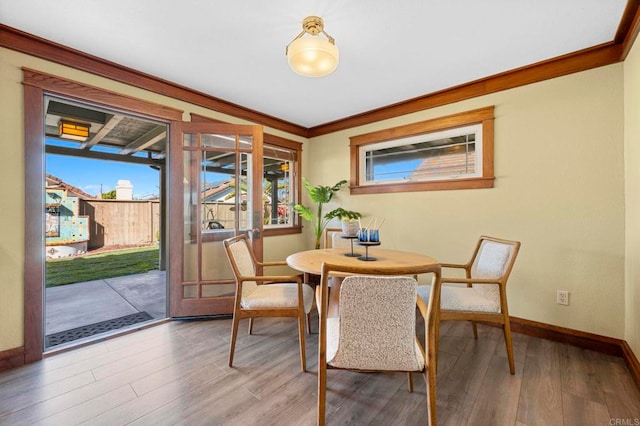 dining space with hardwood / wood-style floors and crown molding