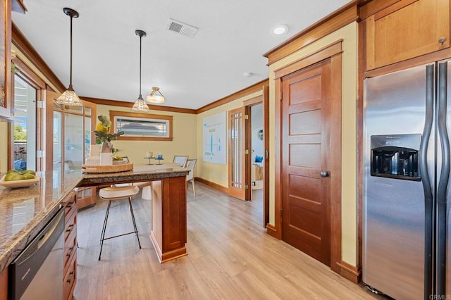 kitchen featuring stone counters, pendant lighting, stainless steel appliances, crown molding, and light wood-type flooring