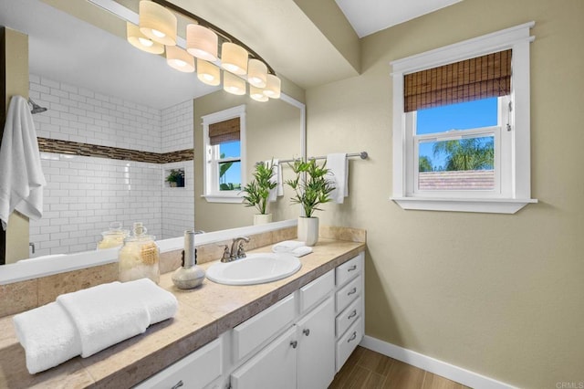 bathroom featuring vanity, wood-type flooring, and a tile shower