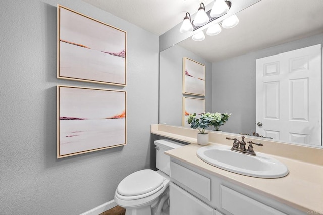 bathroom with vanity, an inviting chandelier, and toilet