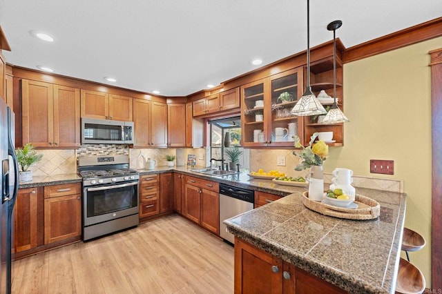 kitchen featuring pendant lighting, sink, a breakfast bar area, kitchen peninsula, and stainless steel appliances