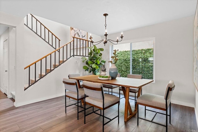 dining room with hardwood / wood-style floors and a notable chandelier