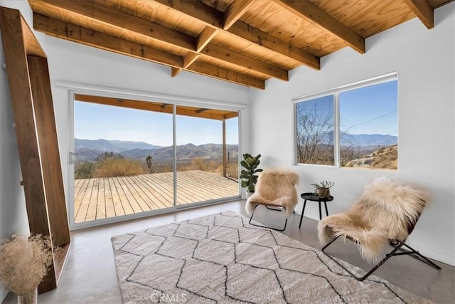 sunroom / solarium featuring a mountain view, wooden ceiling, and beam ceiling