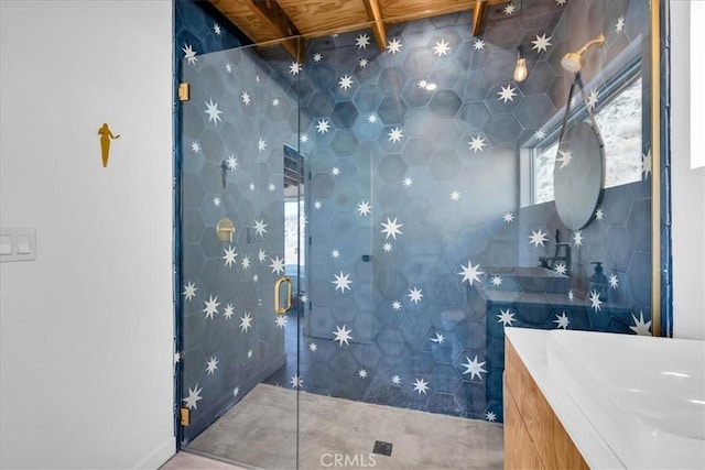 bathroom featuring a shower with door, vanity, and tile walls