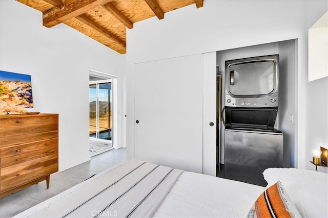 bedroom with concrete floors, beam ceiling, stacked washer / drying machine, access to outside, and a closet