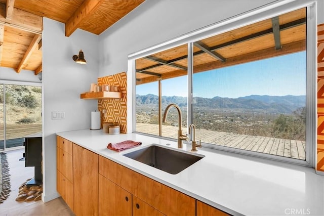 kitchen with a mountain view, sink, beam ceiling, and plenty of natural light