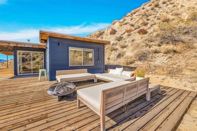 deck with an outdoor living space with a fire pit