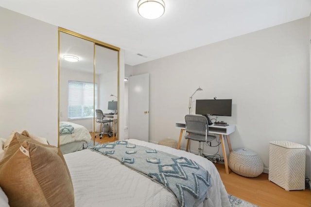 bedroom with wood-type flooring and a closet