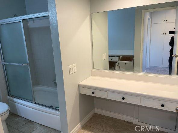 full bathroom with vanity, toilet, tile patterned flooring, and combined bath / shower with glass door