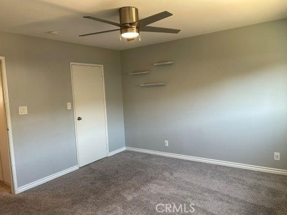 unfurnished room with ceiling fan and carpet flooring