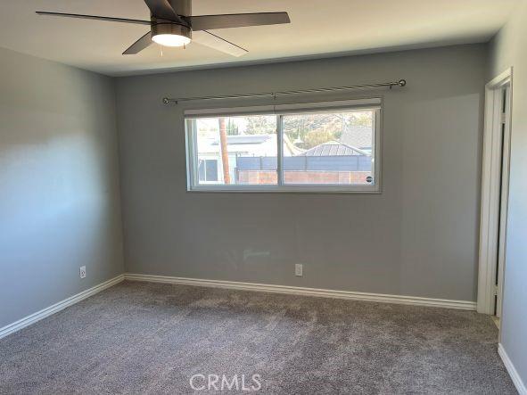 unfurnished room with carpet and ceiling fan