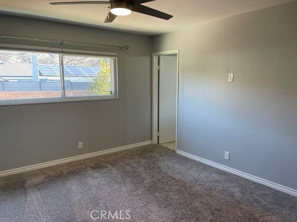 empty room featuring ceiling fan and carpet flooring