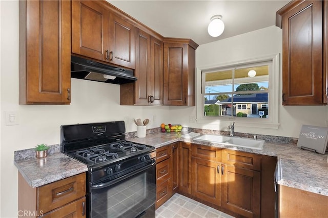 kitchen featuring black gas stove, sink, and light stone counters