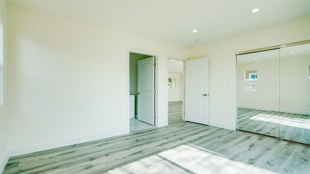 unfurnished bedroom featuring a closet and light wood-type flooring