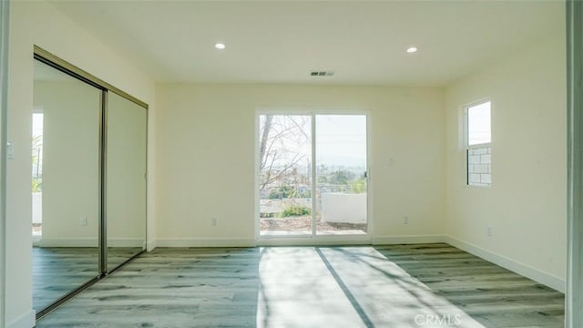 unfurnished bedroom featuring access to outside, light wood-type flooring, and a closet