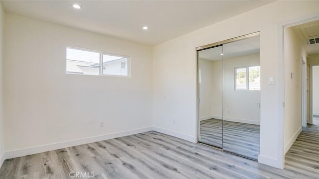 unfurnished bedroom with a closet and light hardwood / wood-style flooring