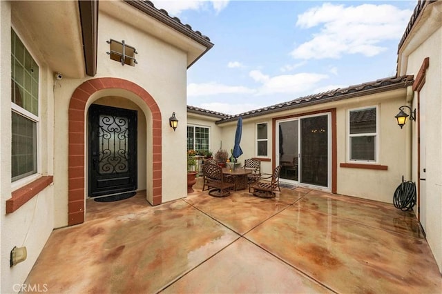 entrance to property featuring a patio area and stucco siding