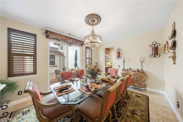 dining area featuring baseboards, light tile patterned floors, visible vents, and an inviting chandelier