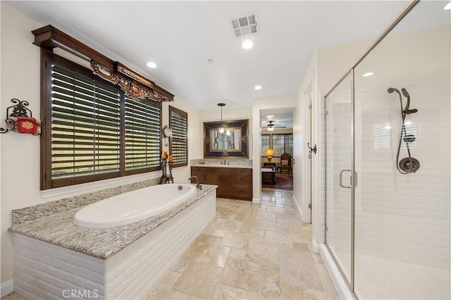 full bathroom with a stall shower, visible vents, stone tile flooring, vanity, and a bath