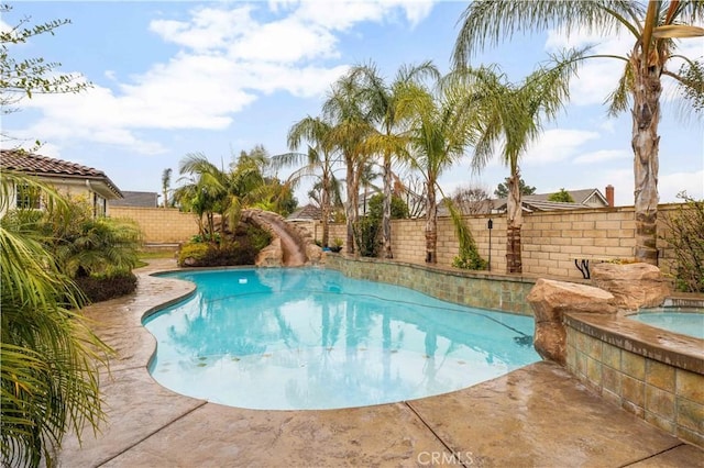 view of pool with a fenced in pool, a water slide, a fenced backyard, and an in ground hot tub