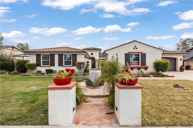 mediterranean / spanish-style house featuring a garage, driveway, a tiled roof, and a front lawn