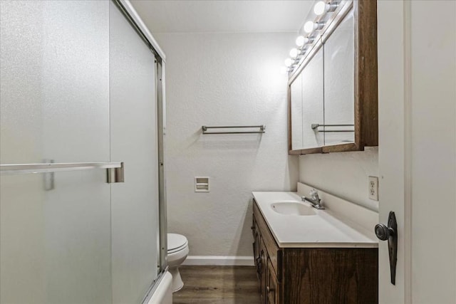 bathroom with hardwood / wood-style flooring, vanity, and toilet