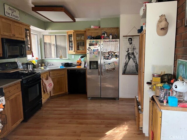 kitchen with sink, light hardwood / wood-style floors, and black appliances