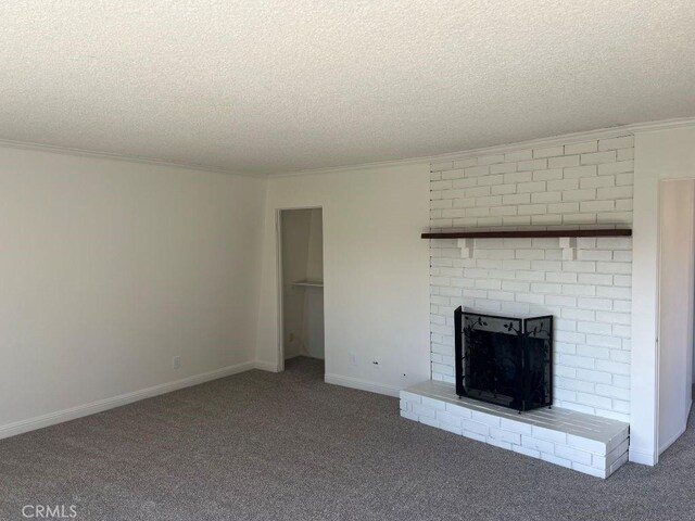 unfurnished living room featuring a brick fireplace, a textured ceiling, crown molding, and carpet floors