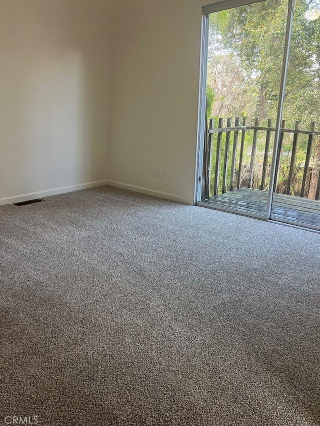 spare room with visible vents, baseboards, and carpet floors