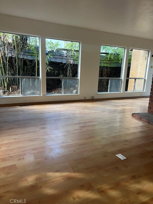 empty room with a wealth of natural light and wood finished floors