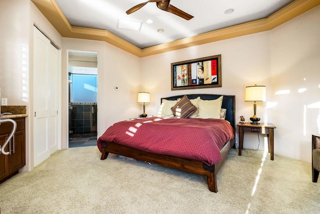 carpeted bedroom featuring connected bathroom and a raised ceiling