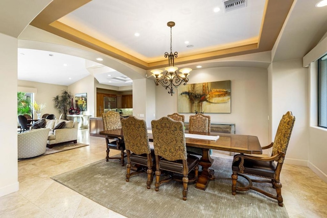 dining room featuring a chandelier and a tray ceiling