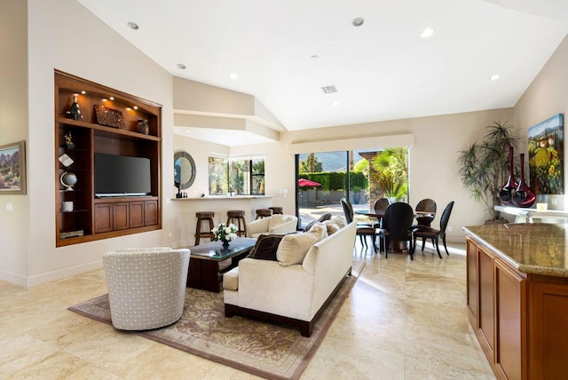 living room with lofted ceiling and built in shelves