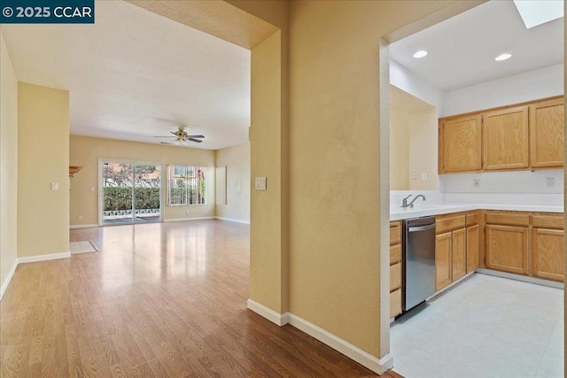 kitchen featuring ceiling fan, dishwasher, sink, and light wood-type flooring