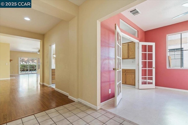 hall featuring light tile patterned floors and french doors