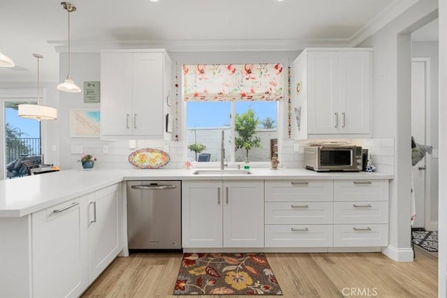 kitchen with white cabinetry, kitchen peninsula, light hardwood / wood-style floors, ornamental molding, and pendant lighting