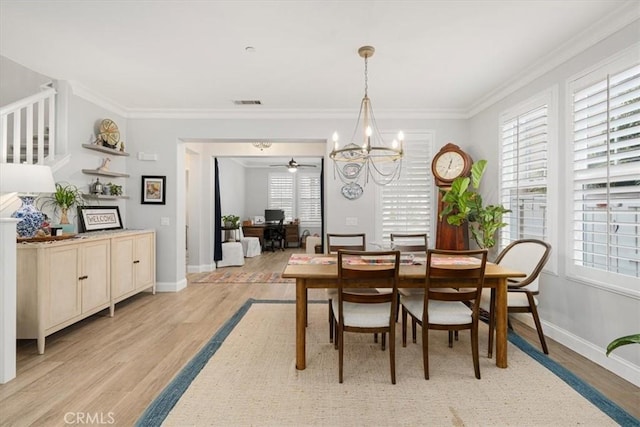 dining room with a healthy amount of sunlight, light hardwood / wood-style flooring, and crown molding