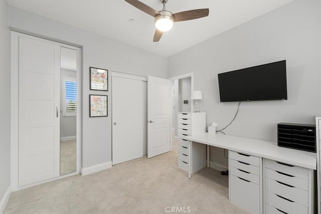 unfurnished office featuring light carpet and ceiling fan