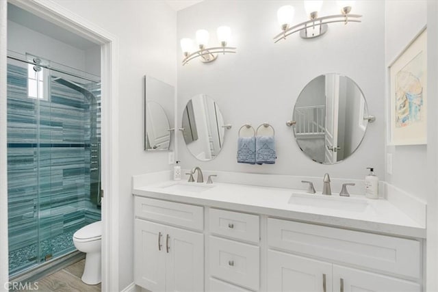 bathroom featuring toilet, wood-type flooring, an enclosed shower, vanity, and an inviting chandelier